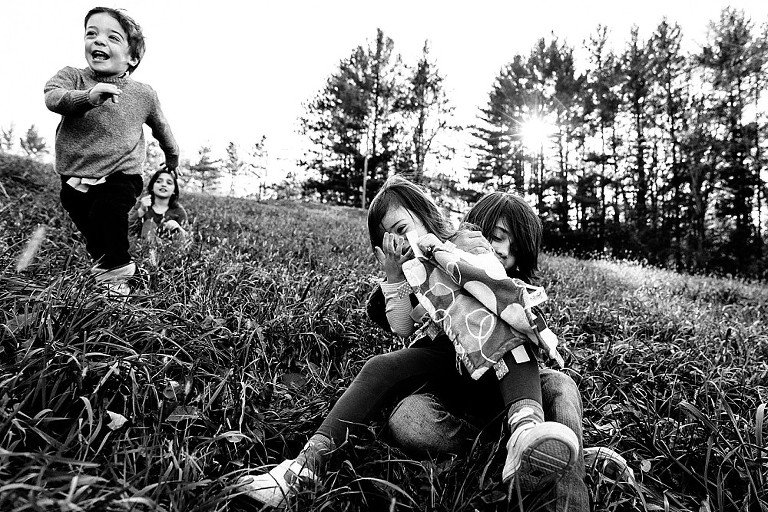Four kids play on a hillside in the wind 