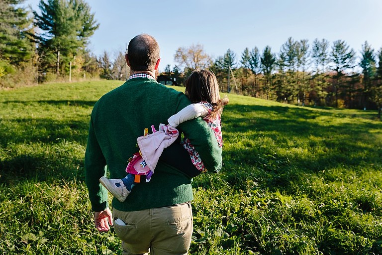 Dad holds daughter walking up a hill