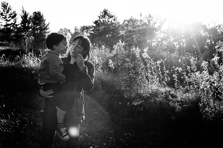 mom holds preschool son in the sun and wind