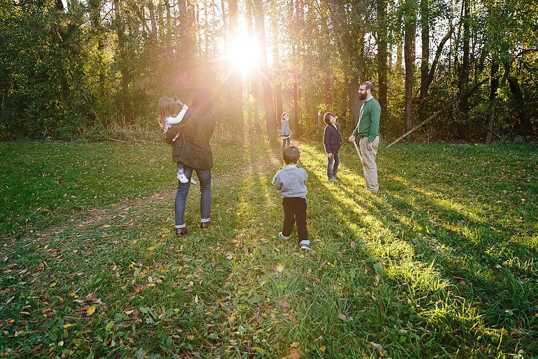 Family walks toward light in the forest 