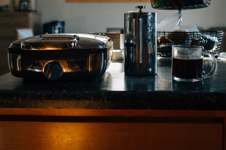 waffle maker, French press, coffee in kitchen.