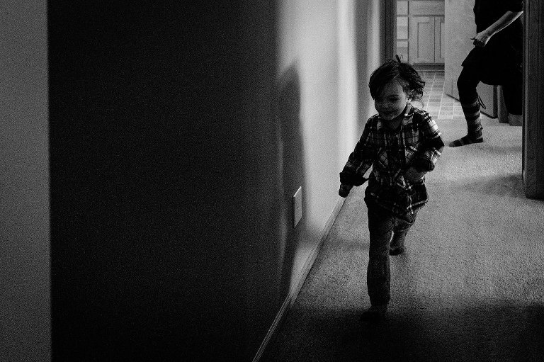 young boy plays chase in the hallway with this mother 