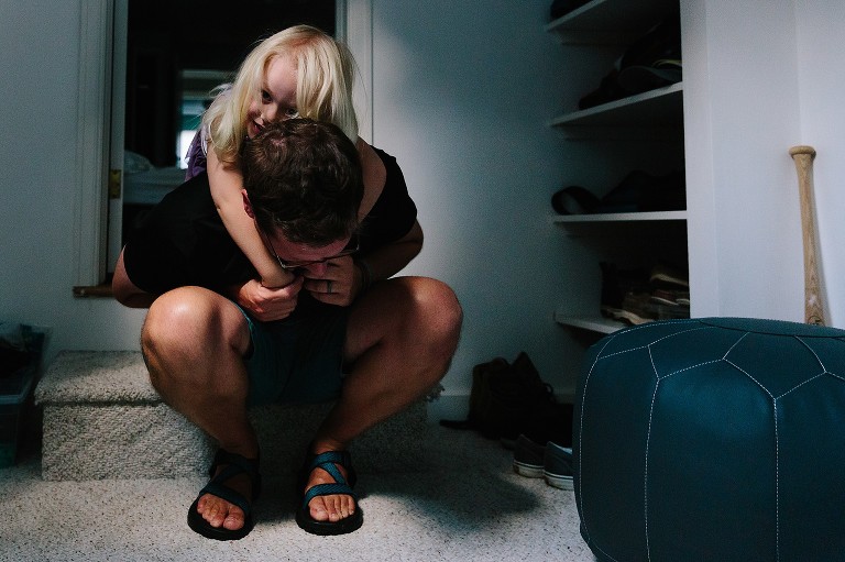 Daughter plays on Dad's back in a sunshine space 