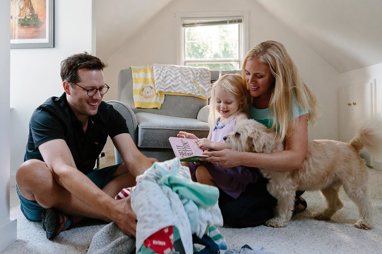 Dad, daughter, mom and dog read a book 