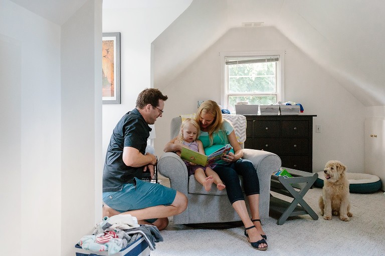 Family of three plus family dog read a book together 