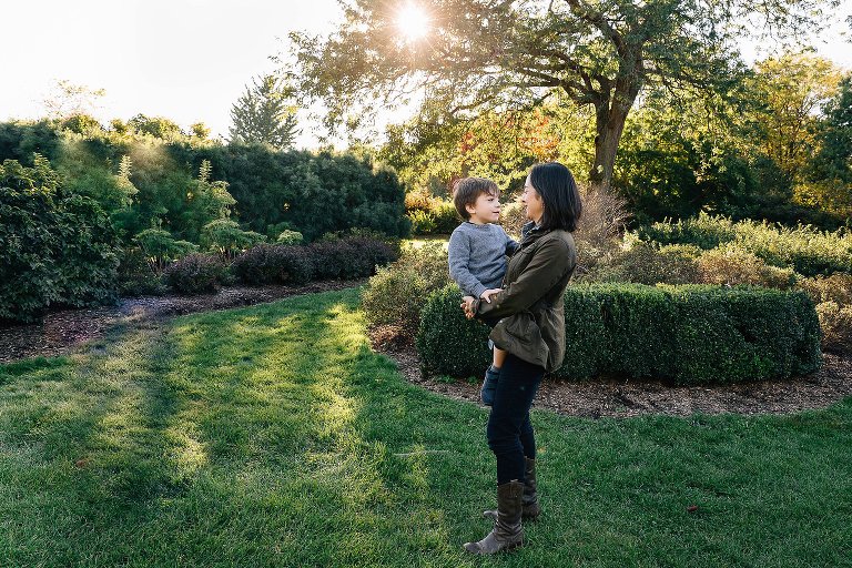 Mom holds young son and talks to him under a warm sun and beautiful fall day. 