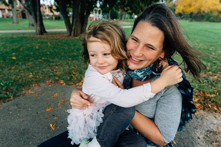 Mother and daughter embrace at the park. 