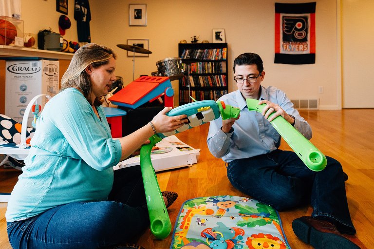 Expectant parents assemble a baby play mat, toy 