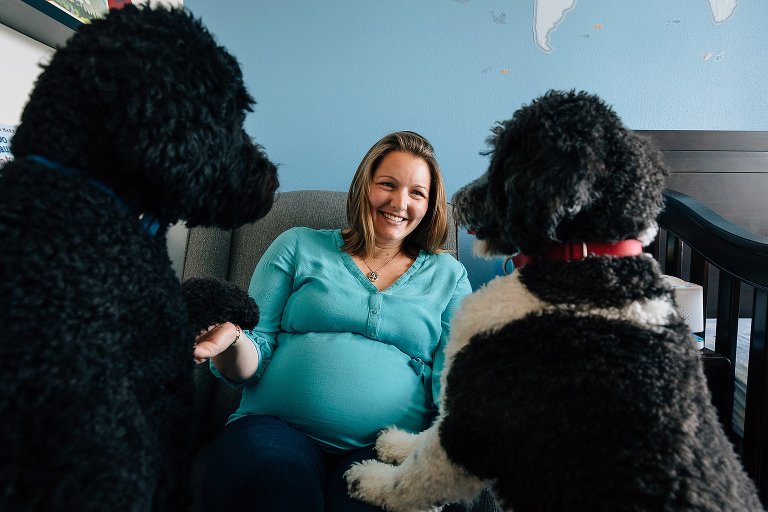 Two family dogs frame expectant mother belly and smiling face