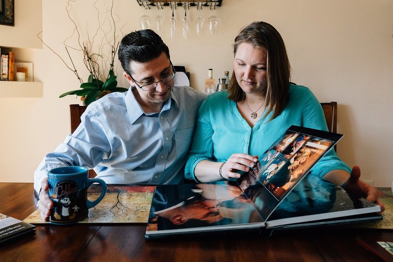 Expectant parents look at wedding album 