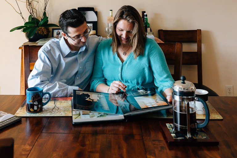 Maternity mother and father look at wedding photos