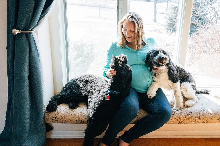 Expectant mother smiles at one of her dogs 