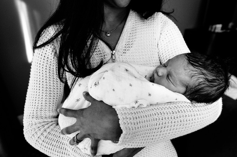 Newborn baby sleeps in mom's arms 