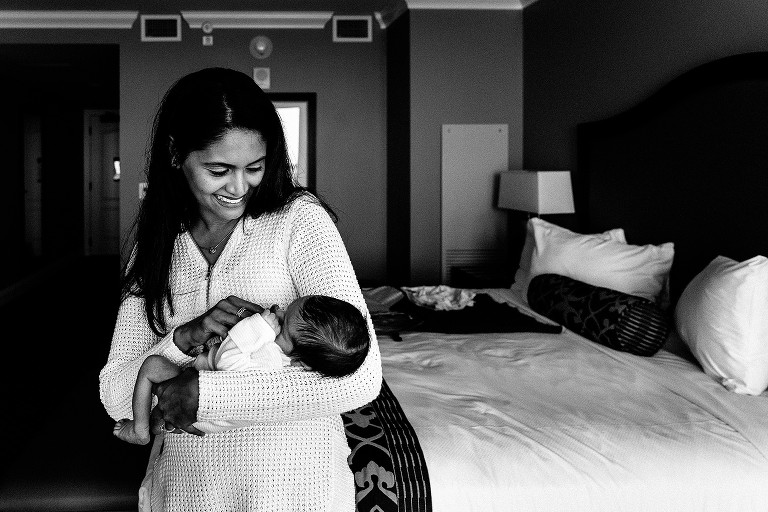 mom holds newborn and smiles 