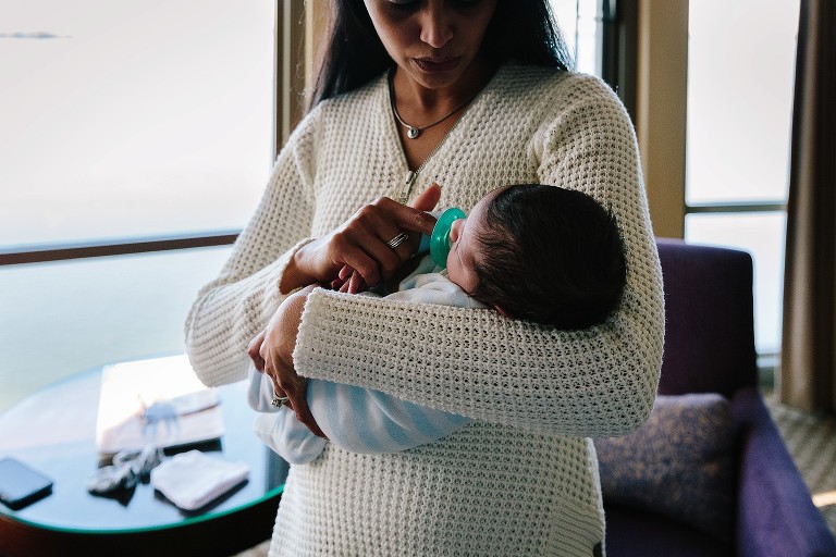 mom holds pacifier in baby's mouth 