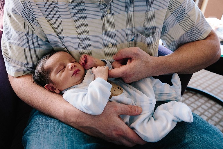 Dad holds newborn hand