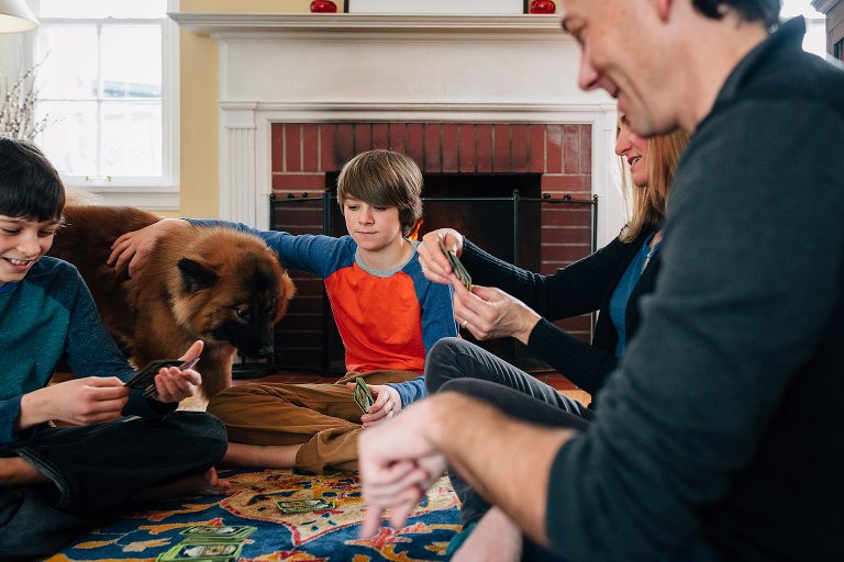 boy pets family dog while everyone plays a game