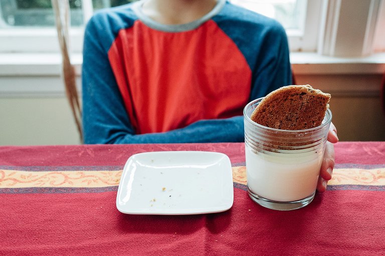 Teen boy has milk and cookie