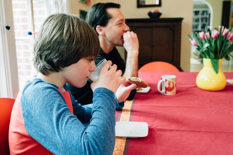 Dad and son have cookie and milk/tea snack 