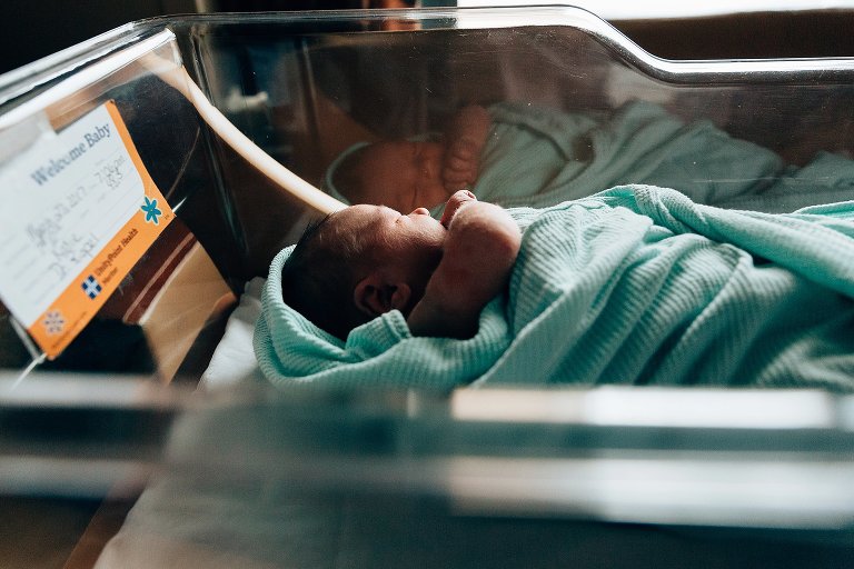 Newborn reflection in bassinet in hospital room