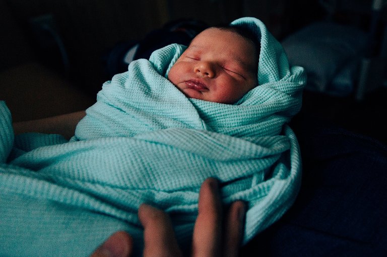 New dad holding baby at hospital 