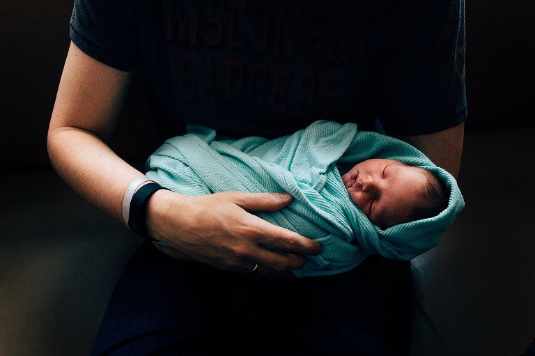 Dad holding newborn baby. Hospital blanket, hospital bracelet.