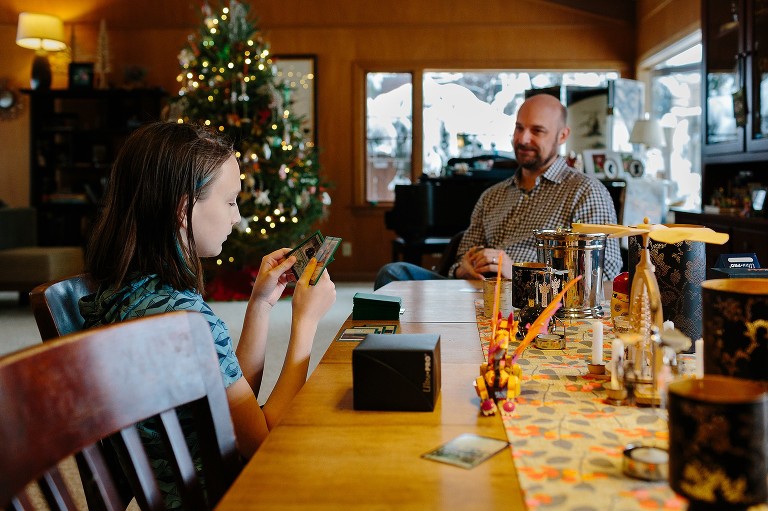 Boy plays cards with dad at Christmastime