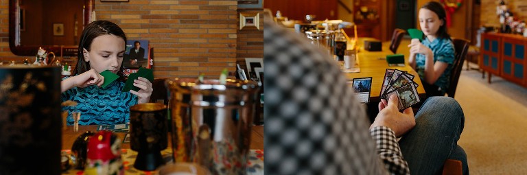 Son and dad play cards together at dining room table 