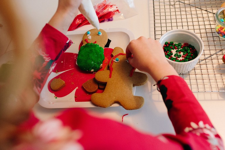 Girl makes candy gingerbread eye with left hand and right hand at same time.