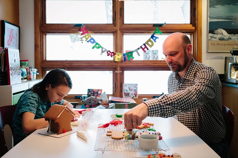 Dad and preteen boy work together decorating gingerbread men