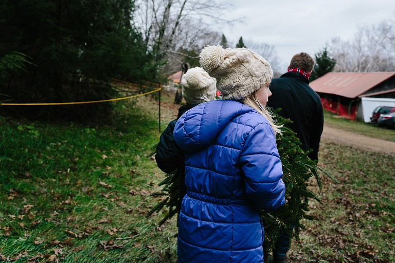 Daughter carries Christmas tree 