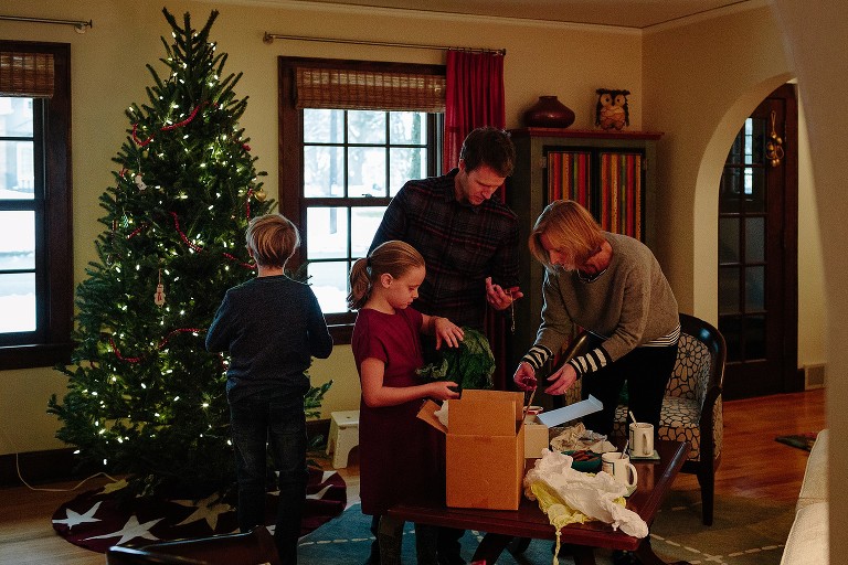 Family decorates Christmas tree in living room