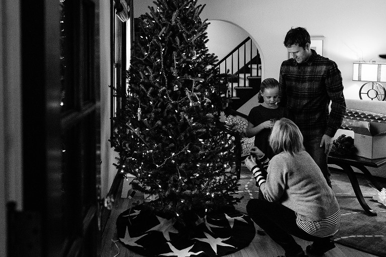 Family decorates Christmas tree in living room
