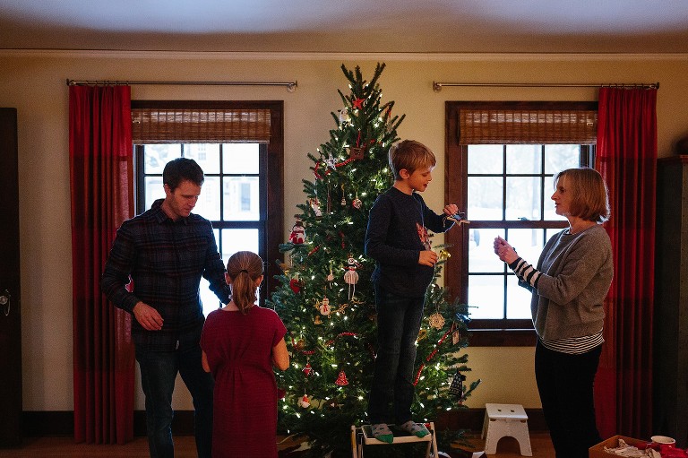 Family decorates Christmas tree in living room