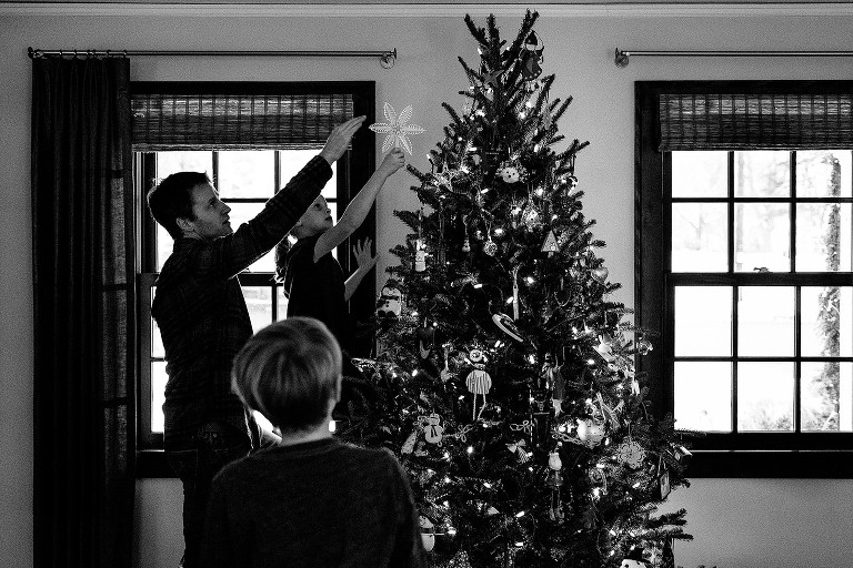 Family decorates Christmas tree in living room