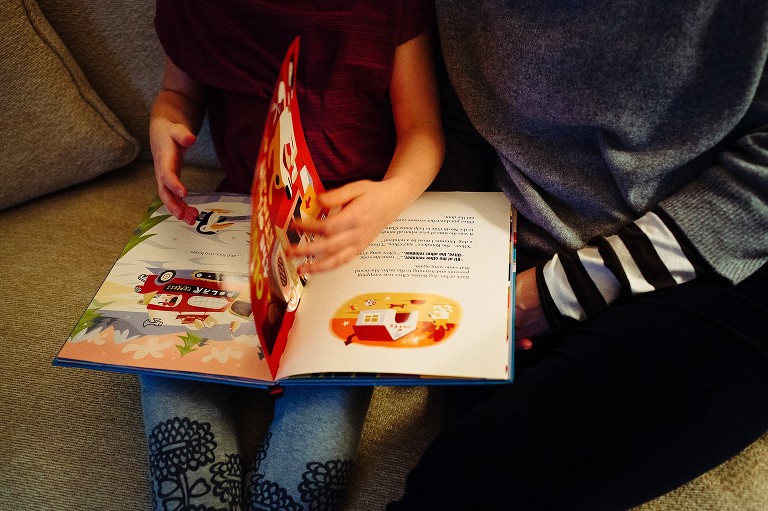 mom and daughter read Christmas story on the couch 