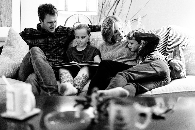 Family of four reads Christmas story on the couch 