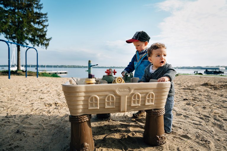 Brothers play at the beach on late spring morning 