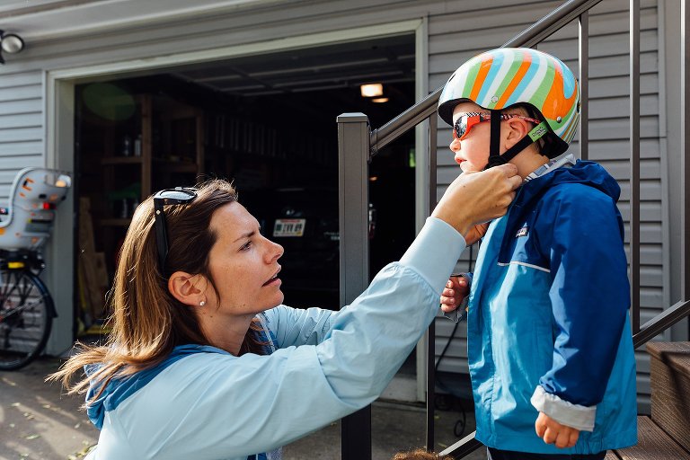 Mom helps snap young boy's helmet 
