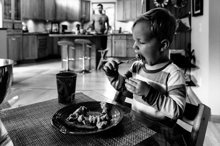 Preschool boy eats forkful of waffle