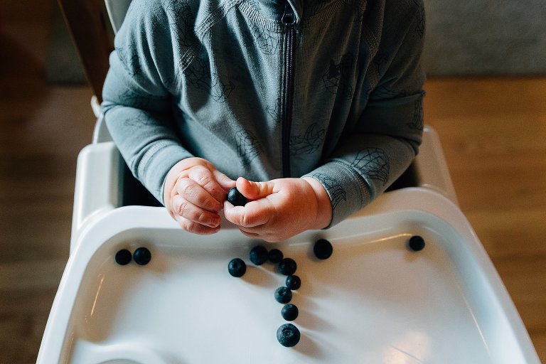 Toddler boy eats blueberries
