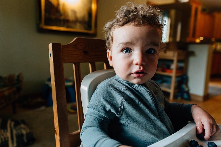 Toddler boy eats blueberries