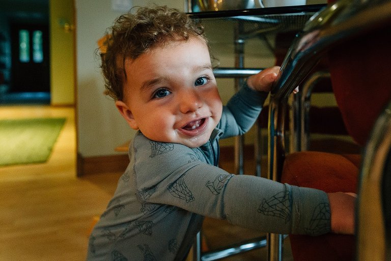 Toddler stands using a chair as balance