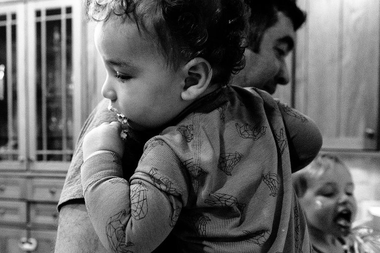 Toddler has whipped cream on face while preschooler eats from the beaters