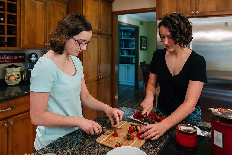 Two teens slice strawberries