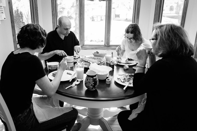 Family of four eats breakfast together.