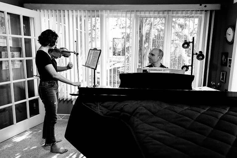 Dad and teen daughter play violin and piano duet 