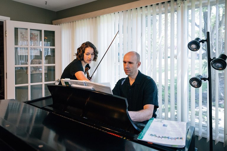 Dad and teen daughter play violin and piano duet 