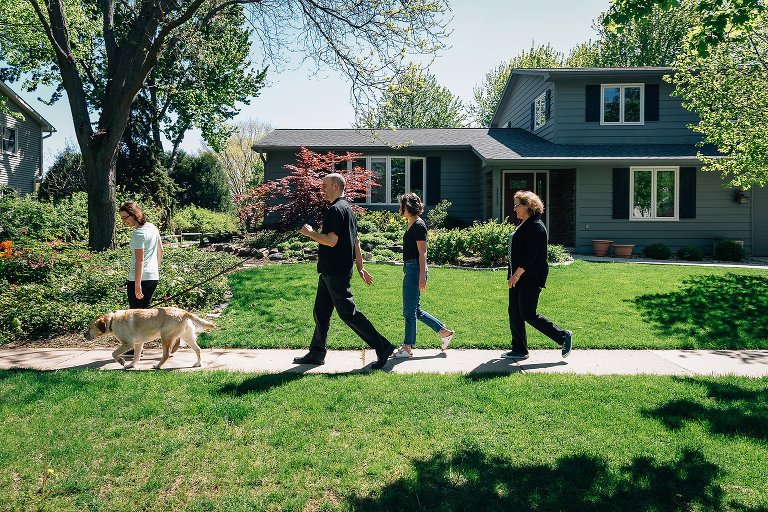 Family of four and dog go for a family walk in the spring. 