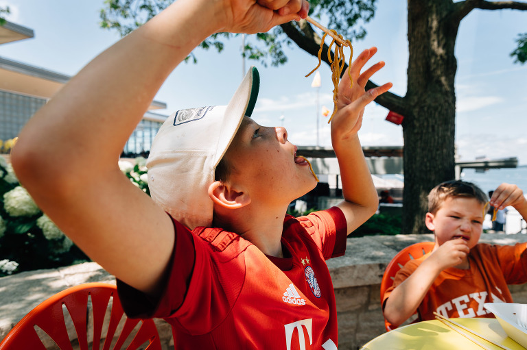 Child eats noodles with chopsticks 